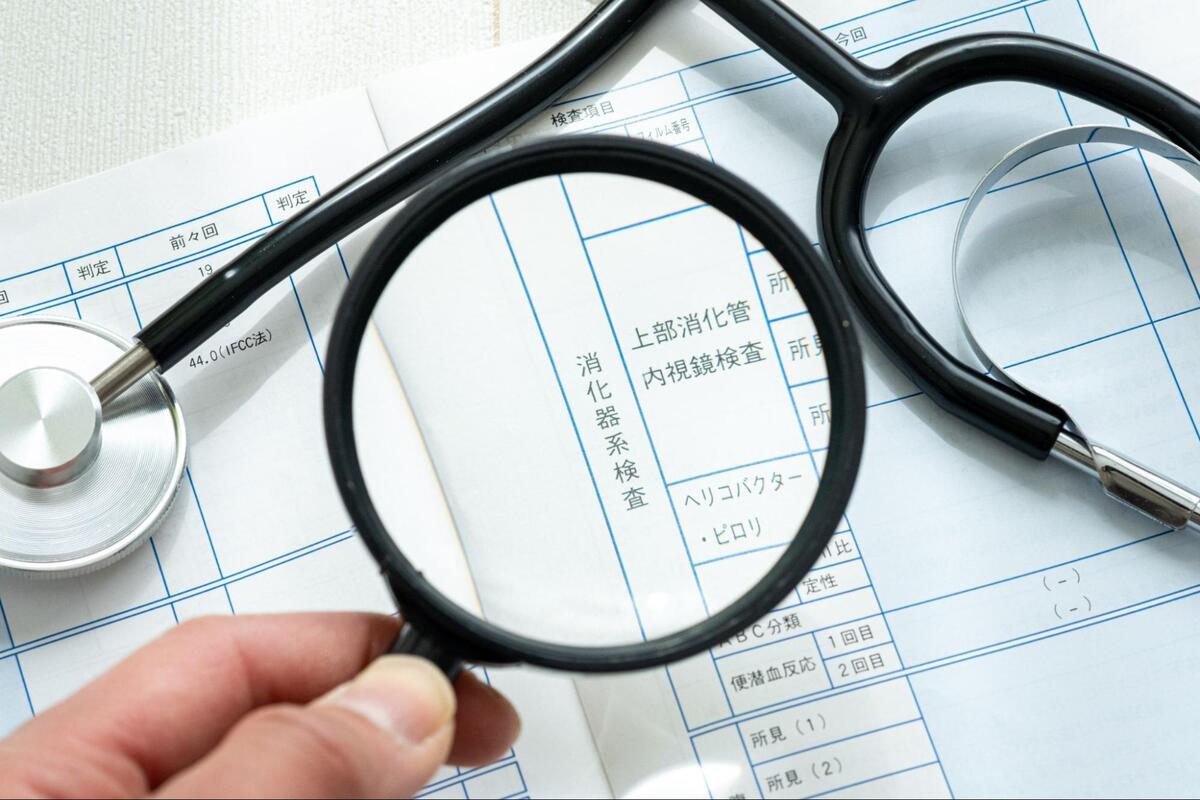 検診の結果用紙の消化器系検査の欄をルーペで拡大している