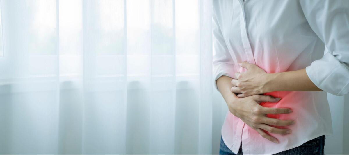 胃のあたりを押さえている様子