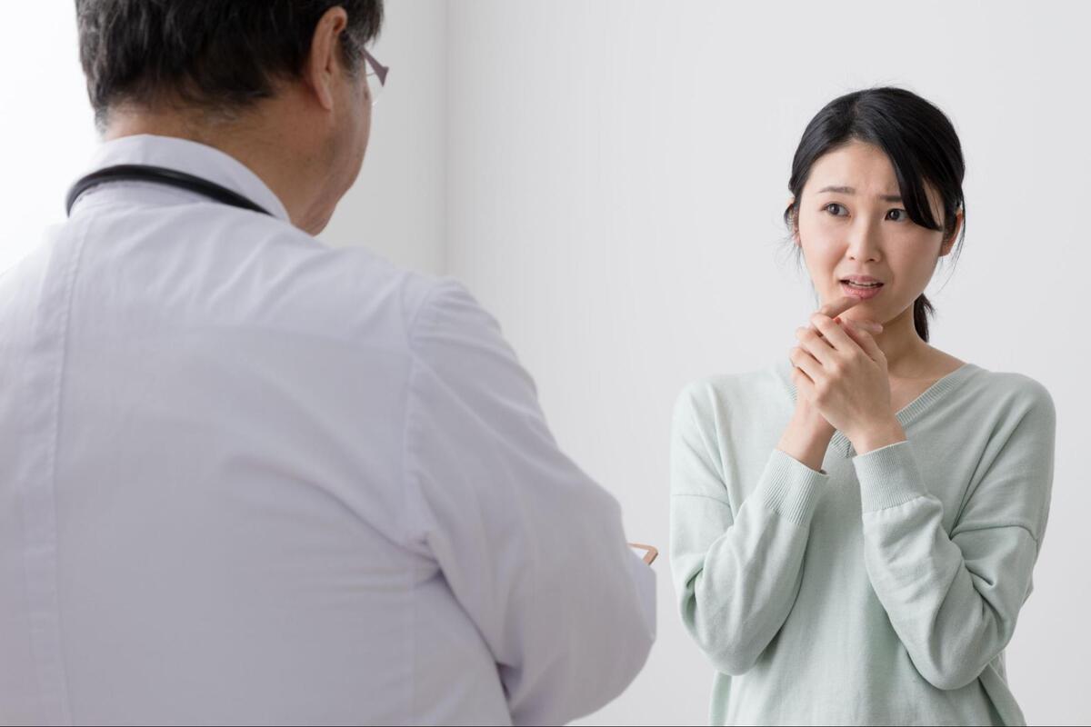 大腸内視鏡検査の組織採取の痛みについて説明を受けている女性